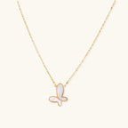 Delicate gold butterfly necklace with white mother of pearl wings on fine chain, displayed on neutral background.